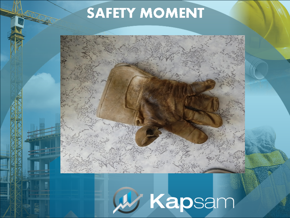 "Poster mit der Überschrift 'Safety Moment'. Im Zentrum ein stark abgenutzter, verschmutzter Arbeitshandschuh auf hellem Untergrund. Das Poster ist von Bau-Motiven wie Kran, Helm und Arbeitshandschuhen umrahmt. Unten das Logo von Kapsam."