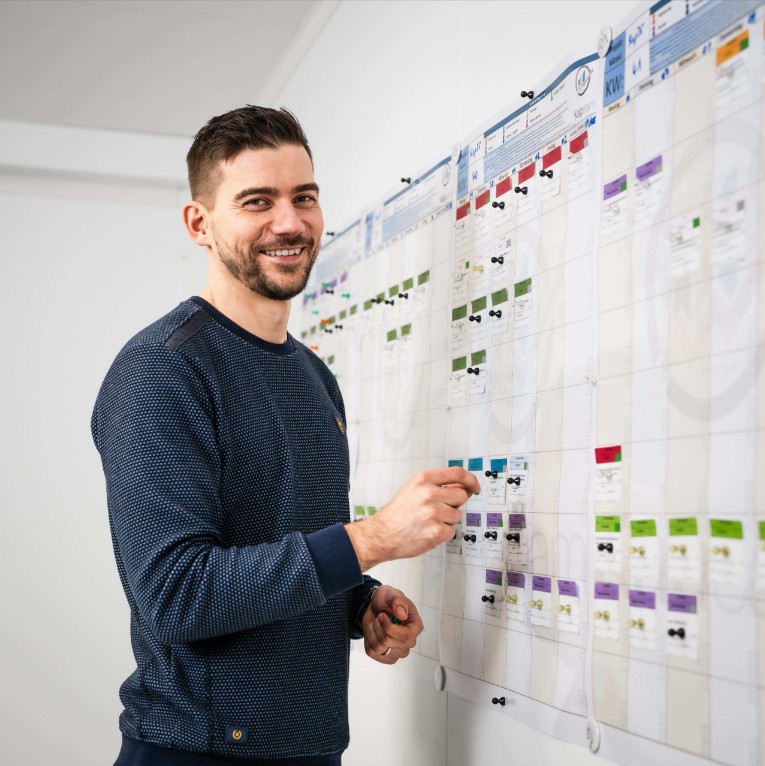 Lean Construction Management mit visueller Bauablaufplanung: Projektbeteiligter aktualisiert ein Planungboard zur Terminsteuerung, Taktplanung und Optimierung von Baustellenprozessen.